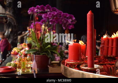 Rote Kerzen mit unscharfen Leute im Hintergrund innen Longhsan buddhistischen Tempel beten in Taipei, Taiwan Stockfoto