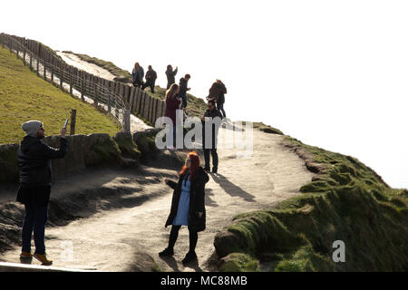 Junge Paare nehmen Sie Fotos von sich selbst auf den Cliffs of Moher, County Clare, Irland Stockfoto