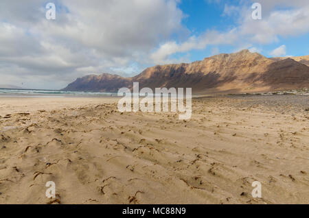 Famara Strand an der nördlichen Küste ofLanzarote, die Kanarischen Inseln, mit riesigen Felsen und Dramatischer Himmel Stockfoto