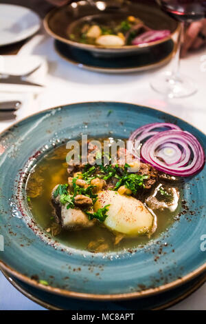 Kaukasische Suppe Putuk (Piti) von Hammel Brust, Kichererbsen, Kartoffeln in der Platte auf dem Tisch Stockfoto