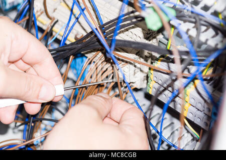 Ingenieur Hände Installation von elektrischen Komponenten im Sicherungskasten. Industrie 4. Messung der Spannung Stockfoto