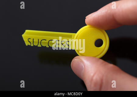 Der Geschäftsmann, der Hand, die eine Gelbe Taste, zeigt Erfolg Text Stockfoto