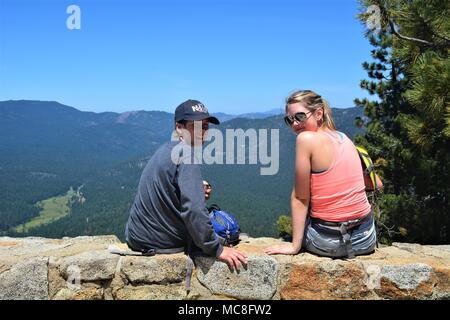 Zwei Teens machen Sie eine Pause vom Wandern mit einem herrlichen Blick auf das Tal bei Wawona im Yosemite National Park, Kalifornien, USA Stockfoto