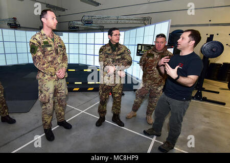 Von Rechts, Michael Kennicker, Kursleiter Gunfighter Fitnessraum, zeigt am Sgt. Maj. Gaetano Massimo Giordano italienische Armee, Oberstleutnant Giuseppe Galloro Chief Training Office der 85 Reggimento Addestramento Volontari "Verona" und Kapitän Daniele Trenteni des Regiments "Savoia Cavalleria "folgore Brigade Grosseto, simulierten schießen Bohrer an Gunfighter Fitnessraum, Caserma Del Din, Vicenza, Italien, 28. März 2018. Italienische Soldaten mit US-Armee RTSD Süden Ausrüstung die bilateralen Beziehungen zu verbessern und die Zusammenarbeit und die Kapazität des Personals in gemeinsamen Aktionen beteiligt zu erweitern. Stockfoto