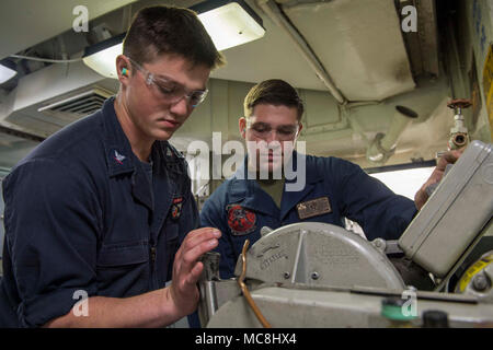 Ozean - (29. März 2018) Marine Corps Lance Cpl. Tristan Johnson, Marine Aviation Logistics Squadron 39 zugeordnet, und Luftfahrt strukturellen Mechaniker 3. Klasse Gunnar Newton ein Schlauch mit einem Schlauch cut-off-Maschine in das Flugzeug Intermediate Instandhaltungsabteilung hydraulische Shop an Bord Wasp-Klasse amphibisches Schiff USS Essex (LL 2) während einer amphibischen Squadron und Marine Expeditionary Unit (MEU) Integration (PMINT) Übung zu trimmen. PMINT ist ein Training Entwicklung zwischen Essex Amphibious Ready Gruppe und 13 MEU, Matrosen und Marines als zusammengehörige Einheit in Vorbereitung für Th zu trainieren Stockfoto