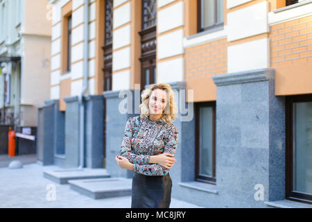 Weibliche Person lächelnd und stand in der Nähe von Gebäude im Außenbereich. Stockfoto