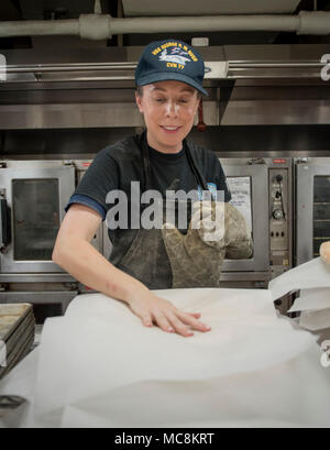 ATLANTIC OCAN (31.03.2018) Air Traffic Controller Airman Stefany Newell, aus Rochester, New York, glättet Wachspapier zu trennen Pizza Teig in Vorbereitung für Samstag Pizza Abend an Bord der Flugzeugträger USS George H.W. Bush (CVN 77). Das Schiff ist im Gange, die Erhaltung übungen Träger bereit zu halten. Stockfoto