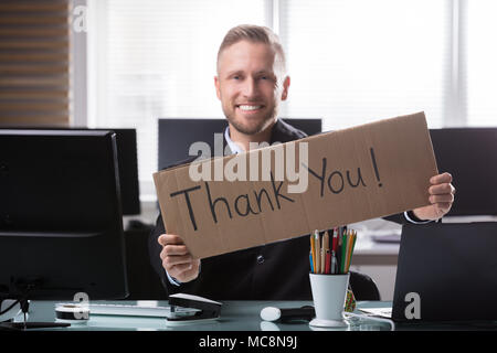 Porträt eines lächelnden Jungen Geschäftsmann Holding Pappe mit vielen Dank Text Stockfoto