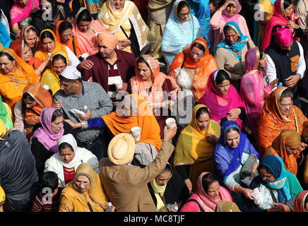 Mitglieder der Sikh Gemeinschaft folgen dem Guru Granth Sahib, dem heiligen Buch der Sikhs, während der nagar Kirtan Prozession durch Gravesend, Kent, die Teil der Sikh Vaisakhi Festival im Frühjahr Ernte für die Bauern und Gemeinschaften im Punjab in Nordindien Kennzeichnung. Stockfoto