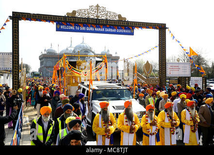 Mitglieder der Sikh Gemeinschaft folgen dem Guru Granth Sahib, dem heiligen Buch der Sikhs, während der nagar Kirtan Prozession von der Guru Nanak Darbar Gurdwara und durch Gravesend, Kent, die Teil der Sikh Vaisakhi Festival im Frühjahr Ernte für die Bauern und Gemeinschaften im Punjab in Nordindien Kennzeichnung. Stockfoto