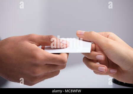 In der Nähe von zwei Geschäftsleute, die Hand, die eine leere weiße Karte Stockfoto