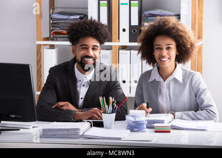 Porträt von zwei junge lächelnde Geschäftsleute im Büro Stockfoto