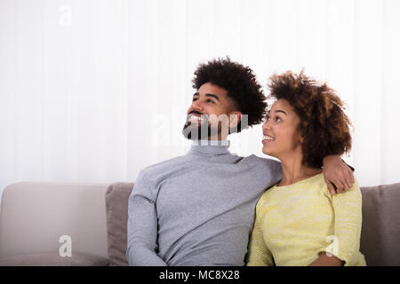 Nahaufnahme der junge lächelnde Paar sitzt auf einem Sofa Stockfoto