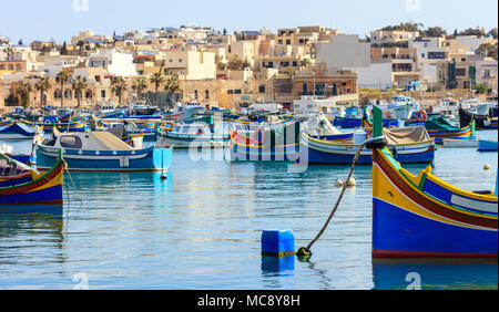 Marsaxlokk, Malta Insel. Traditionelle Fischerboote luzzus mit hellen Farben verankert im Hafen von Marsaxlokk Stockfoto