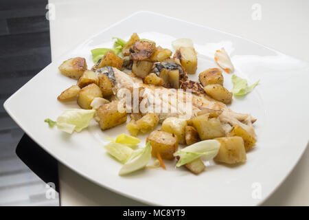 Seebarsch im Gericht mit Kartoffeln und Salat Stockfoto