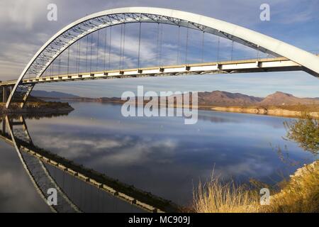 Roosevelt Bridge Arch Ellipse spiegelt sich im Apache Trail Lake Calm Water. Scenic Superstition Mountains Landscape Angle View, Arizona Südwesten der USA Stockfoto