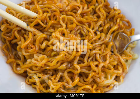 Schüssel Nudeln und Sauce, Essstäbchen. Hintergrund Stockfoto