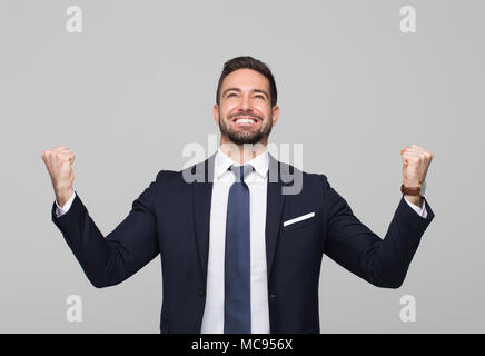 Erfolgreiche Junge kaukasier professionelle Sieger Geschäftsmann auf grauem Hintergrund Stockfoto