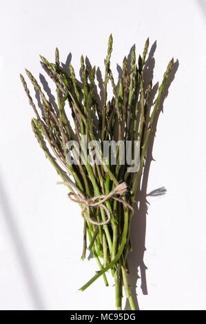 Wilder Spargel in Strauß auf weißer Tisch, bereit für die Nutzung Stockfoto