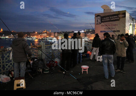 Männer Angeln mit Angelruten aus der oberen Ebene der Galata Brücke in Istanbul, Türkei Stockfoto