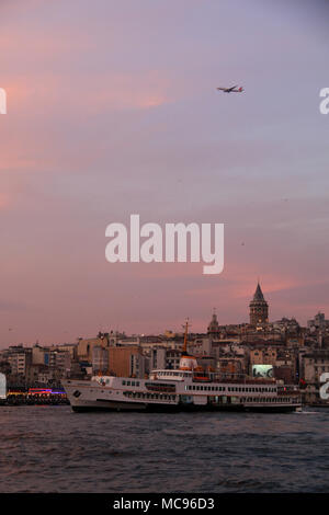 Fähre "barış Manço' navigieren durch das Goldene Horn, während einer Boeing 777 Überfliegen der Stadtteil Galata, Galata Tower in Istanbul, Türkei Stockfoto