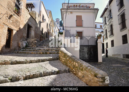 Alte mittelalterliche Straße mit Steinboden und Treppen, und weissen typischen alten Häusern im arabischen Viertel Albaicín in Granada (Andalusien, Spanien) Stockfoto