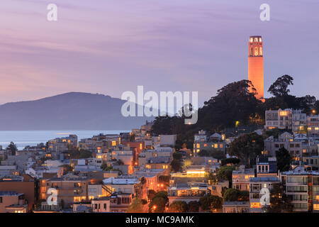 Coit Tower auf Telegraph Hill mit der San Francisco Bay und Angel Island im Hintergrund in der Abenddämmerung. Stockfoto