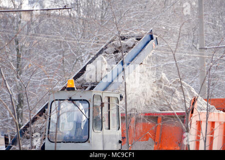 Traktor Reinigung der Straße vom Schnee. Bagger säubert die Straßen von großen Mengen an Schnee in der Stadt. Die Arbeiter von der Straße fegen Schnee im Winter, Cleani Stockfoto