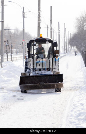 Bagger säubert die Straßen von großen Mengen an Schnee in der Stadt. Winter Konzept Stockfoto