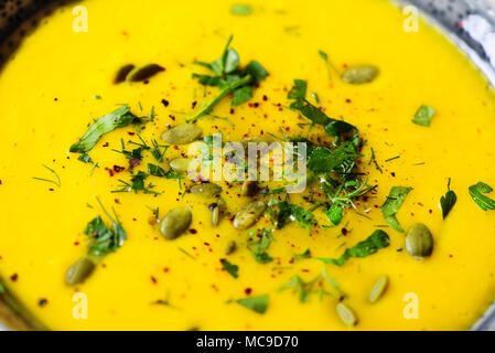 Hell Bio Kürbis, Linsen und Karotten Suppe mit Samen und Kräutern auf hellgrauem Hintergrund. Kopieren Sie Raum, Ansicht von oben Stockfoto
