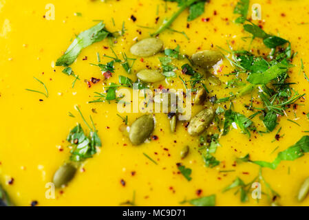 Hell Bio Kürbis, Linsen und Karotten Suppe mit Samen und Kräutern auf hellgrauem Hintergrund. Kopieren Sie Raum, Ansicht von oben Stockfoto