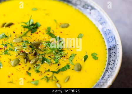 Hell Bio Kürbis, Linsen und Karotten Suppe mit Samen und Kräutern auf hellgrauem Hintergrund. Kopieren Sie Raum, Ansicht von oben Stockfoto