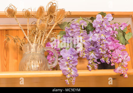 Bukett von getrockneten Blumen in Vase auf Holz Hintergrund, Blumen in Vase, schöne bunte Kunststoff Blumenstrauß in der Vase. Stockfoto