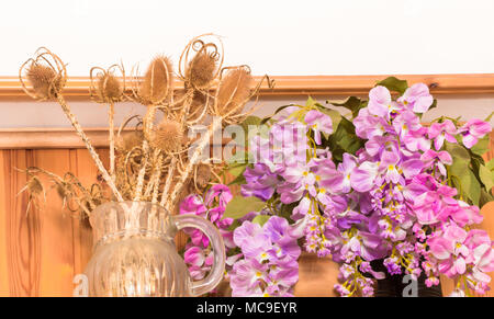 Bukett von getrockneten Blumen in Vase auf Holz Hintergrund, Blumen in Vase, schöne bunte Kunststoff Blumenstrauß in der Vase. Stockfoto