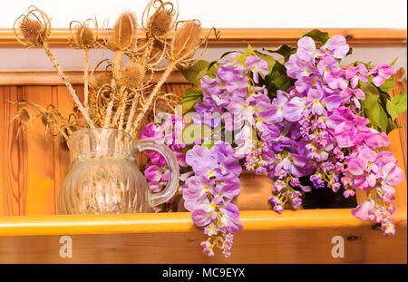 Bukett von getrockneten Blumen in Vase auf Holz Hintergrund, Blumen in Vase, schöne bunte Kunststoff Blumenstrauß in der Vase. Stockfoto