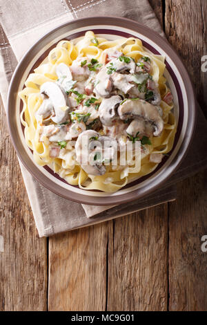 Fettuccine mit traditionellen Italienischen cremige Boscaiola sauce Closeup auf einem Teller auf dem Tisch. Vertikal oben Ansicht von oben Stockfoto