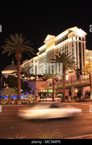 Schöne lange Exposition bei Nacht ein Auto vorbei am Caesars Palace Hotel und Casino Hotel auf dem Strip, Las Vegas, NV, USA Stockfoto