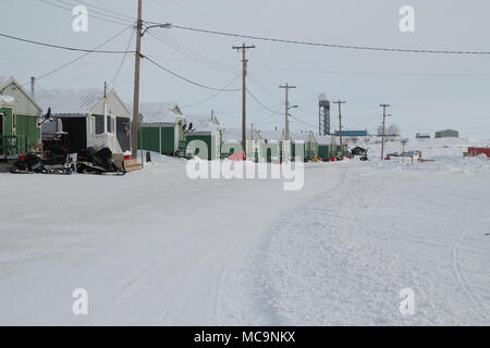 Gehäuse in der arktischen Weiler Tuktoyaktuk im Winter, mit der verlassenen entfernten Early Warning Line in der Ferne, Northwest Territories, Kanada. Stockfoto