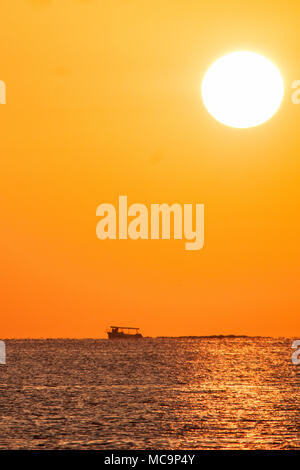 Sonnenaufgang, Sonnenuntergang am Hollywood Beach, Florida mit Silhouetten von Schiffen und Booten in der Ferne. Stockfoto