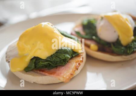 Eggs Benedict. Pochiertes Ei auf Muffin mit Schinken, Baby Spinat & Sauce Hollandaise Stockfoto