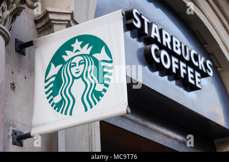 Ein Starbucks Namen und Zeichen über der Tür, ein Starbucks Coffee Shop. Stockfoto