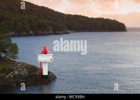 Leuchtturm an der Küste der Norwegischen See. Weißer Turm Red Top steht auf einem Felsen an der Küste Stockfoto