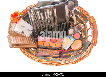 Korb mit Make-up Kosmetik in weißen Hintergrund. Handgefertigten Holz- korb mit Zubehör Make-up-Produkte. Stockfoto