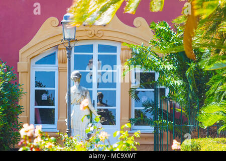 Gärten im europäischen Stil mit Statuen, Lampen und Fenster, die sich von der Silhouette eine schöne Statue Spiegeln geschmückt. Stockfoto