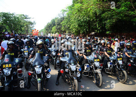 Dhaka, Bangladesch, 14. April 2018. Bangladeshi Polizisten escort eine Prozession von Menschen der erste Tag der Bangla neues Jahr oder 'Pahela Baisshakh', in Dhaka, Bangladesch zu Feiern, am 14. April 2018. Tausende von Menschen in Bangladesch am Samstag feierten ihr Neues Jahr mit Messen, Konzerte und Rallyes. Credit: Mamunur Rashid/Alamy leben Nachrichten Stockfoto