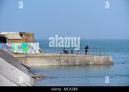 Angler an Gunners Park, Shoeburyness, Southend On Sea, Essex. Angler Angeln von der Ufermauer. Graffiti auf kriegszeiten Geschützstellung. Thames Estuary Stockfoto