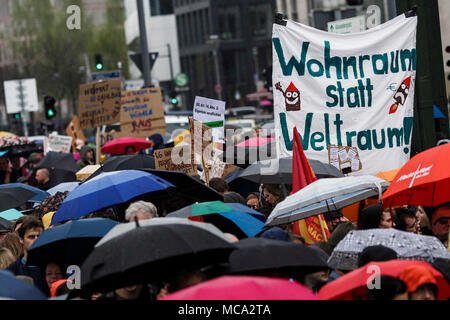 14 April 2018, Deutschland, Berlin: Portestors gegen Wohnungsnot und Mieterhöhungen demonstrieren und ein Schild mit der Aufschrift 'Wohnraum statt Stempel tragen! (Lit. Wohnraum anstelle des Weltraums!). Mehr als 130 Mieten und Stadtpolitik Gruppen aus Berlin rief zu einer Demonstration gegen steigende Mieten und Vertreibung unter dem Motto "Widersetzen · Gemeinsam gegen Verdrängung und Mietenwahnsinn" (Lit. Ablehnen - Gemeinsam gegen Vertreibung und Mieten, Wahnsinn). Foto: Carsten Koall/dpa Stockfoto