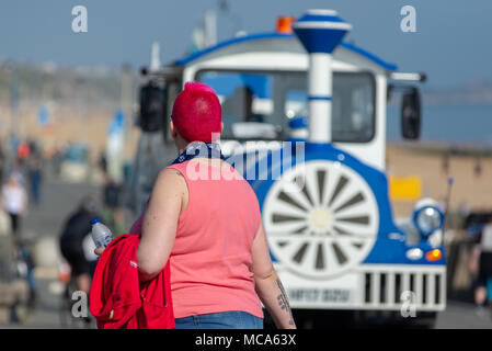 Eine Frau mit kurzen roten Haaren und den blauen und weißen land Zug an der Promenade von englisches Seebad Boscombe, Bournemouth, Dorset, Großbritannien Stockfoto