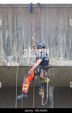 Die Hayward Gallery, Southbank, London, 14. April 2018. Zwei Ingenieure arbeiten an der Außenwand der Hayward Gallery, im Hinblick auf die Zuschauer auf der Waterloo Bridge, spannte in, Abseilen in der Höhe ein Teil der Struktur zu prüfen, und führen Sie einige Reparatur- und Wartungsarbeiten. Credit: Imageplotter Nachrichten und Sport/Alamy leben Nachrichten Stockfoto