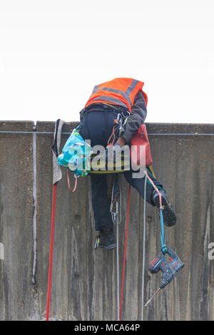 Die Hayward Gallery, Southbank, London, 14. April 2018. Ein Ingenieur kämpft sich zurück über die Mauer zu hissen, amüsante Zuschauer in den Prozess. Zwei Ingenieure arbeiten an der Außenwand der Hayward Gallery, im Hinblick auf die Zuschauer auf der Waterloo Bridge, spannte in, Abseilen in der Höhe ein Teil der Struktur zu prüfen, und führen Sie einige Reparatur- und Wartungsarbeiten. Credit: Imageplotter Nachrichten und Sport/Alamy leben Nachrichten Stockfoto